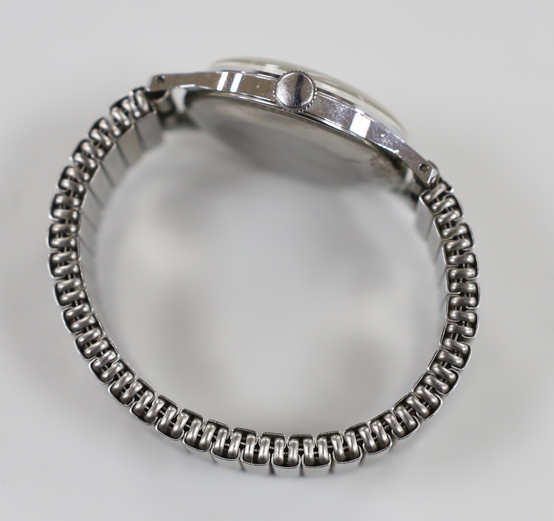 A gentleman's 1960's? stainless steel Smiths Astral National 15 manual wind wrist watch, on an associated flexible bracelet.